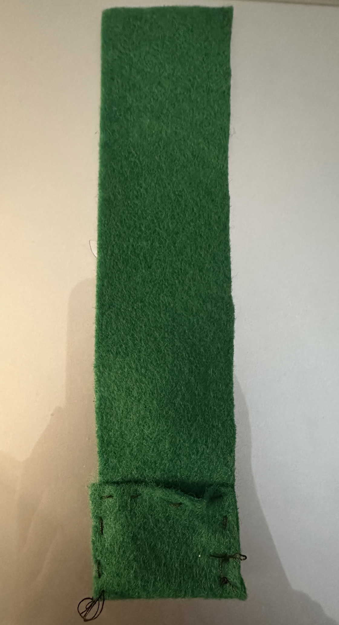 I used felt fabric and conductive thread to sew a small pocket for the battery.