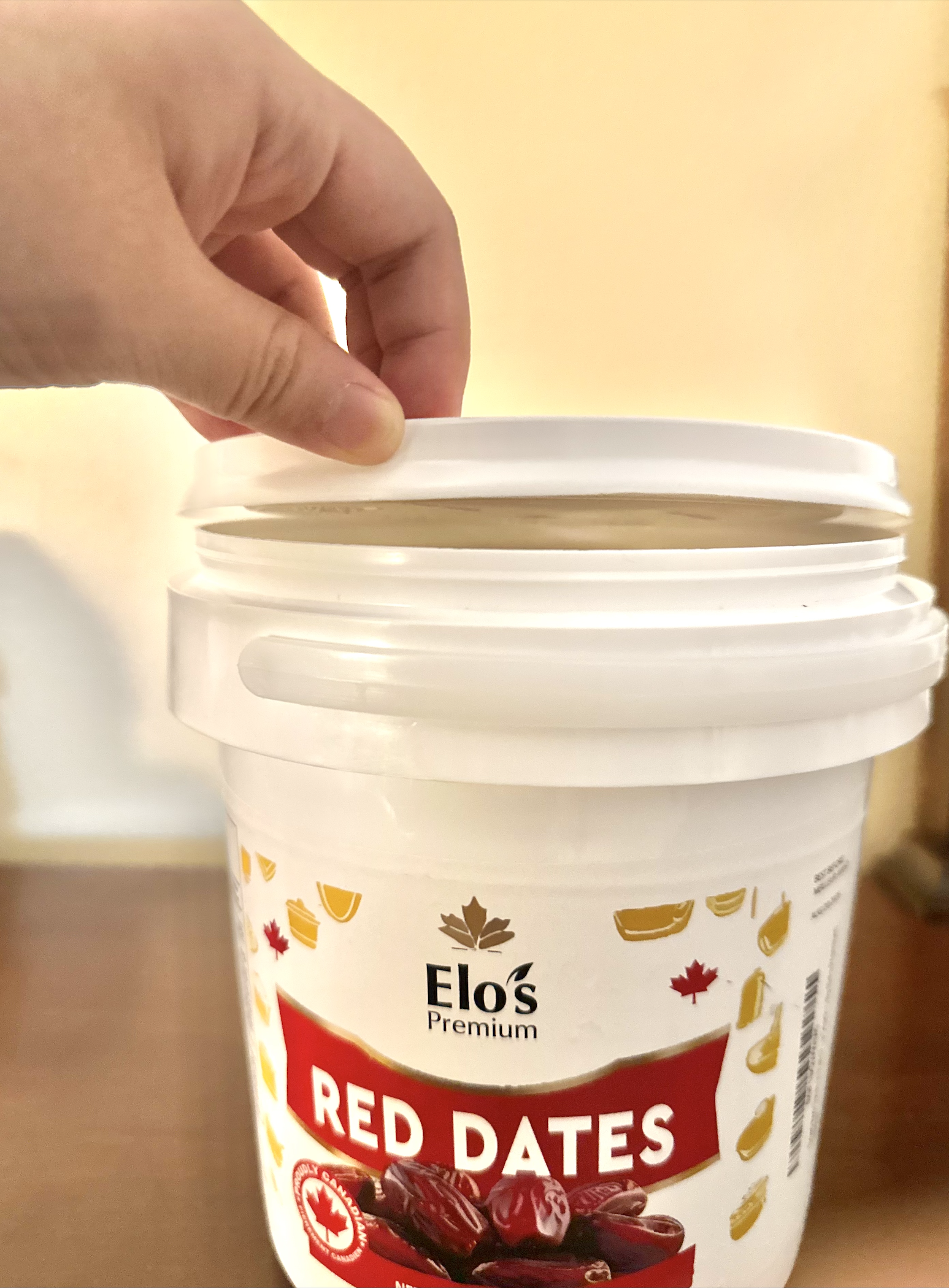 The red date container with the lid open just before pressing it down