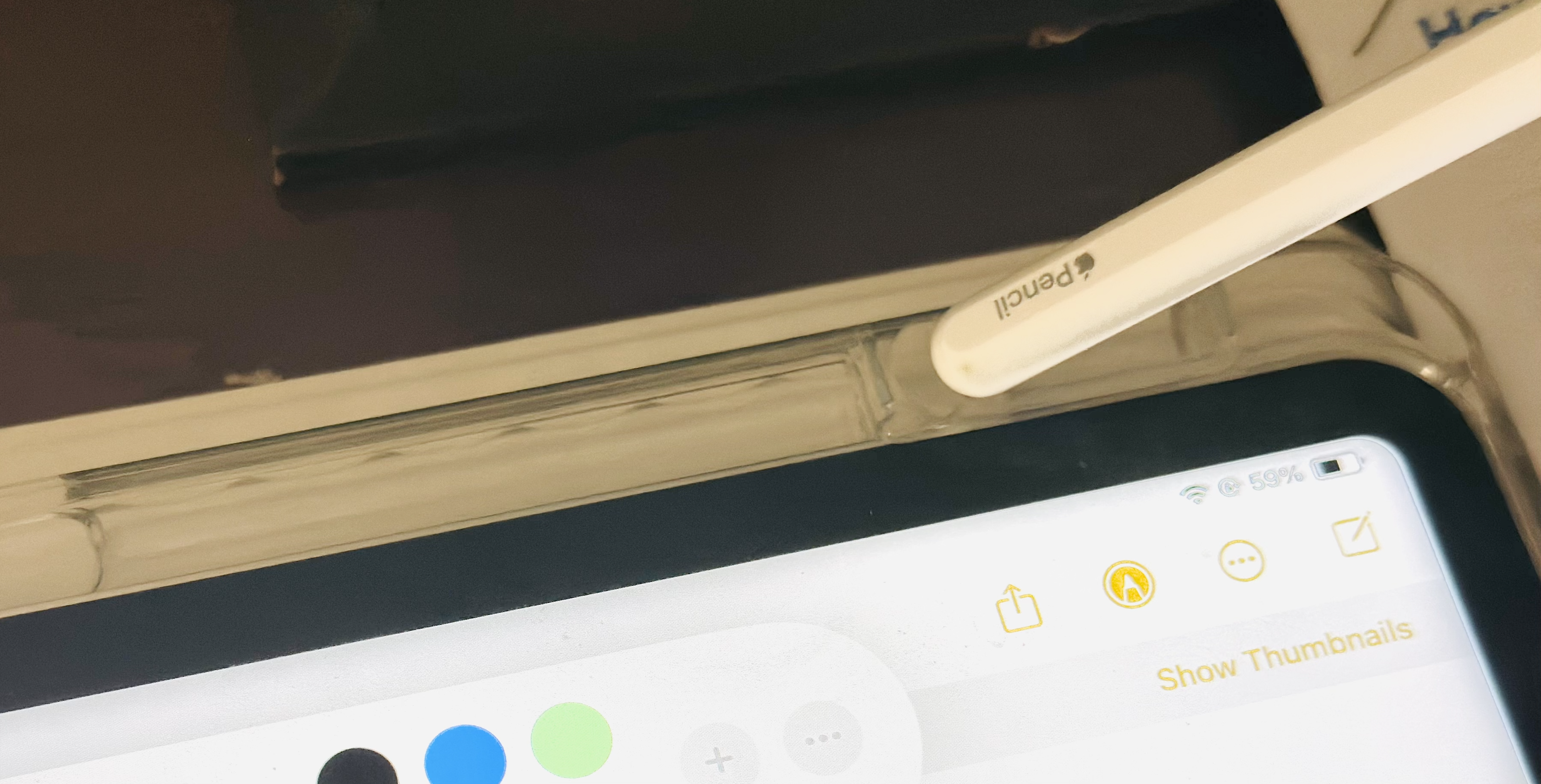 Holding the Apple Pencil above the slot before inserting it