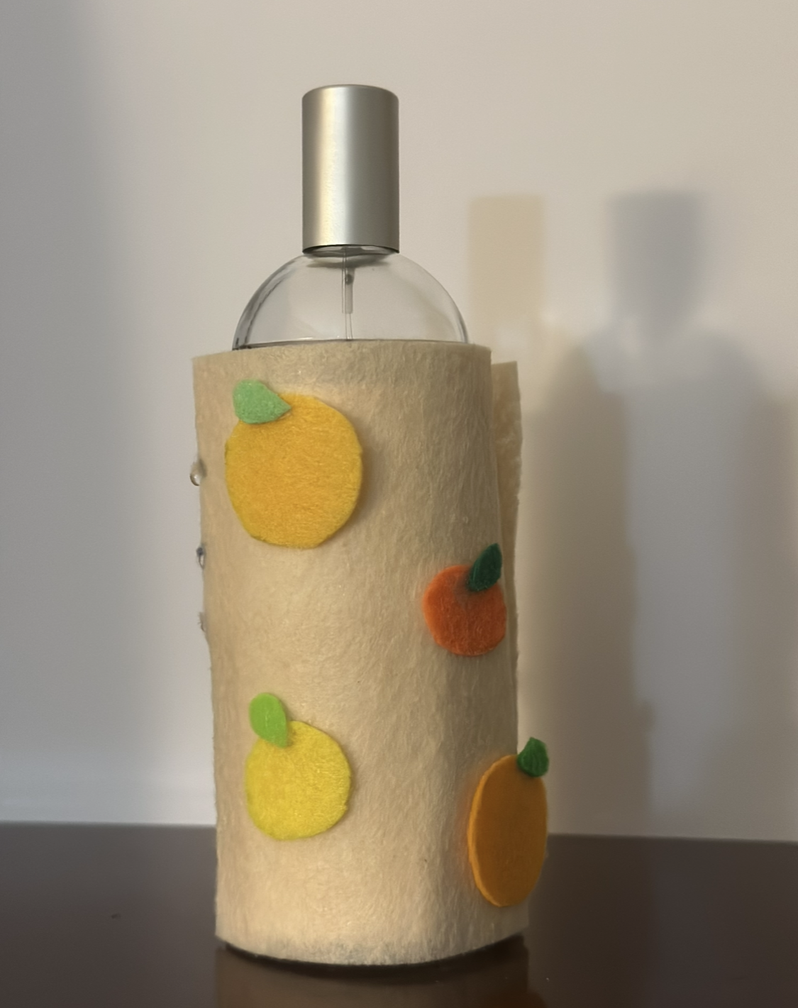 The final sleeve wraps the perfume bottle in a soft citrus themed felt layer that makes the routine feel playful while keeping the interaction clear and easy to notice